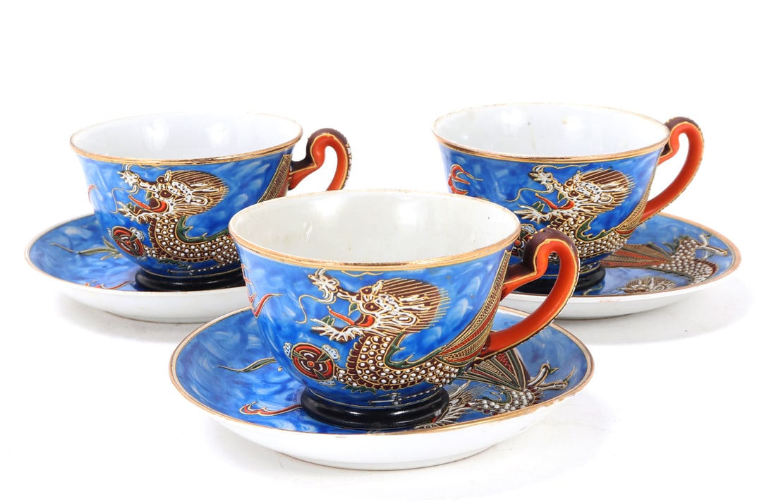 Three Hand Painted Porcelain Teacups & Saucers: Nice group of three porcelain Japanese teacups and saucers. Each hand painted with a lovely blue background. On the face of each a dragon is chasing a flaming pearl, orange and brown painted handles a