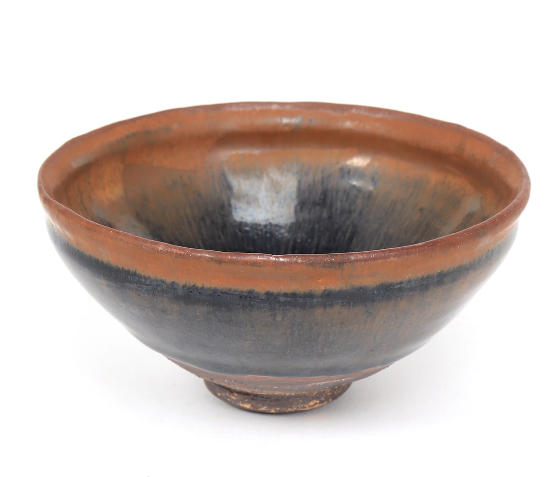 Chinese 'Hare's' Fur Tea Bowl, Song Dynasty: Circa 960-1279 CE, this beautiful porcelain tea bowl is covered in black glaze with hints of midnight blue, and light burnt umber rim. Old inventory sticker to base. Size 2 3/8" H x 5" D