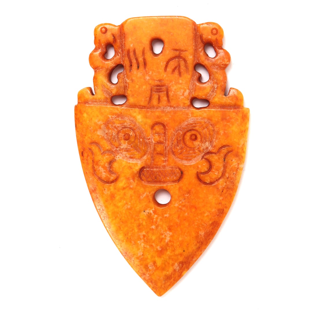 Chinese Orange Jade Style Pendant: Beautiful orange jade style stone pendant in an arrowhead shape, incised zoomorphic beast face to each side, with zoomorphic animals a the top. Pierced at the top for suspension. Size 4 7/8" H x 3