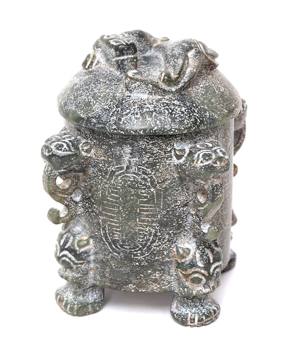 Chinese Green Hardstone Lidded Vessel: Carved Chinese hardstone vessel with zoomorphic archaistic details. Foo dog or lion paw feet with feline faces carved to the body. Panels of archaistic Chinese symbols engraved to the sides. Lid with