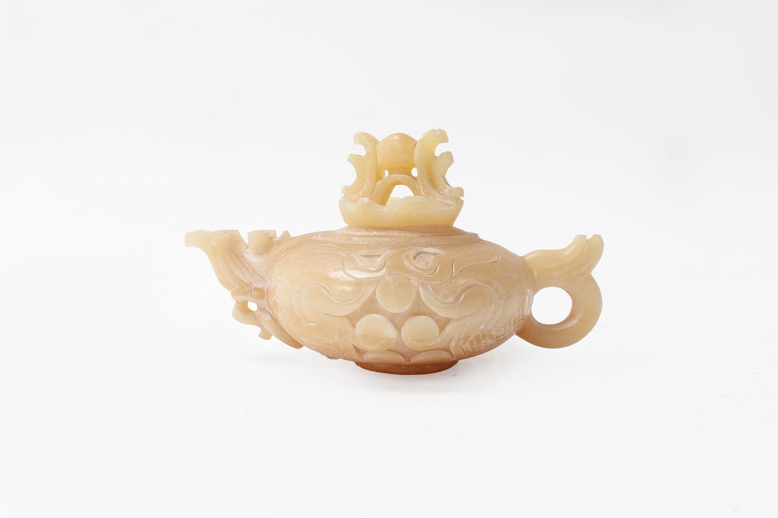 Chinese White Hardstone Teapot: Chinese carved white semi-translucent hardstone pouring vessel. Carved with scrolling and pearls to the body with piercing work to the point and lid. Probably agate hardstone. 9" widet 5" tall