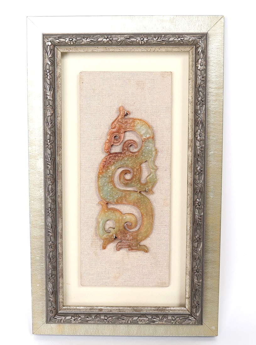 Chinese Dragon Plaque, Framed: Lovely carved jade style stone depicting a fierce dragon, with gorgeous green, orange and red marbling throughout the stone. Mounted in a frame with fabric backing. Size of jade piece 6 1/2" L x 2