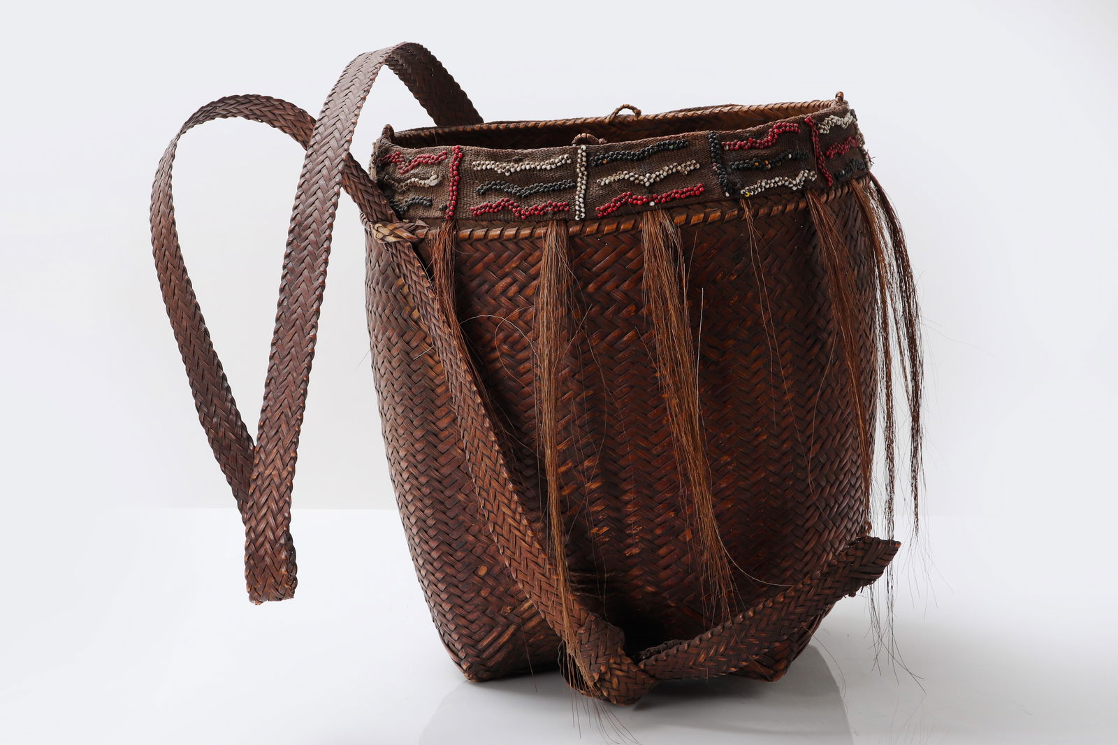 Ifugao Shamans Bamboo Backpack: Ifugao Pasiking Shamans backpack finely woven in interlaced rattan and bamboo. Decorated with horse hair and red, white, and black beadwork. Bontoc Philippines.