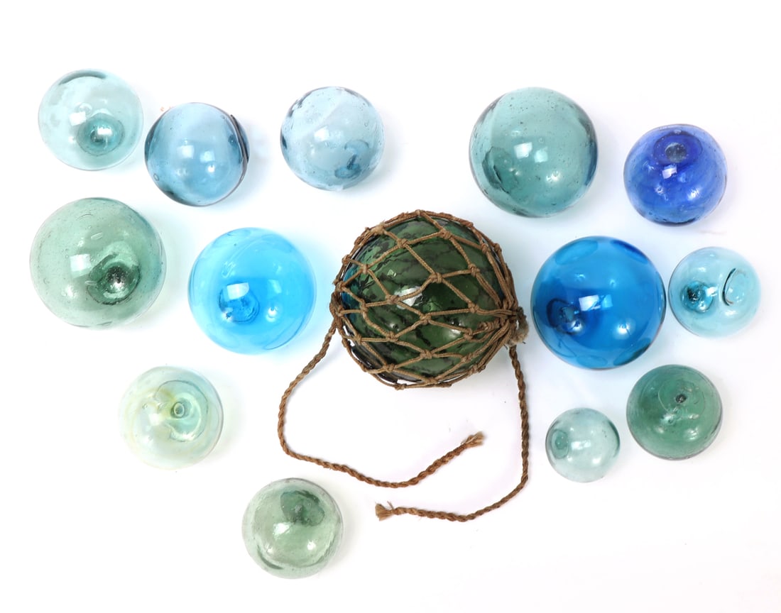 Fourteen Antique WWII Era Fishing Buoy & Floats: Wonderful collection of antique glass WWII era buoy's. Light blue, dark blue, light green and dark green coloring thorughout. Size of largest 5 1/4" W, Lucite stand not included