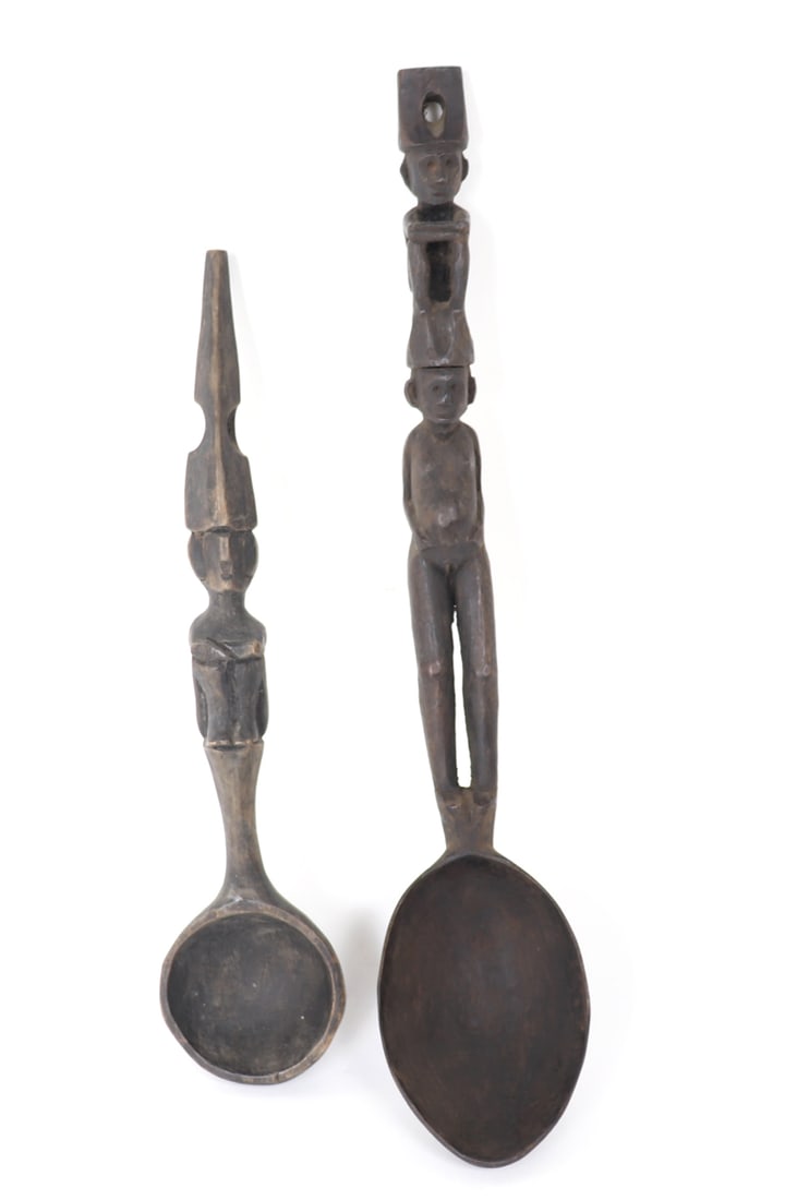 Pair of Carved Filipino Wooden Figural Spoons: Pair of wooden Filipino spoons, both with carved figures as handles. The first shorter spoon with a single carved figure in seated position with long hat which is pierced for hanging. The second