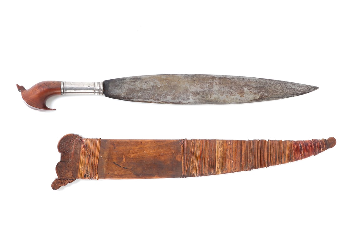 Moro Barong Sword with Scabbard: Sulu Archipelago or Mindanao, Philippines, circa 1900's. Fine example of Filipino blacksmithing and craftmanship, Moro barong sword with wood and rattan wrapped scabbard. Stylized kakatua wood carved