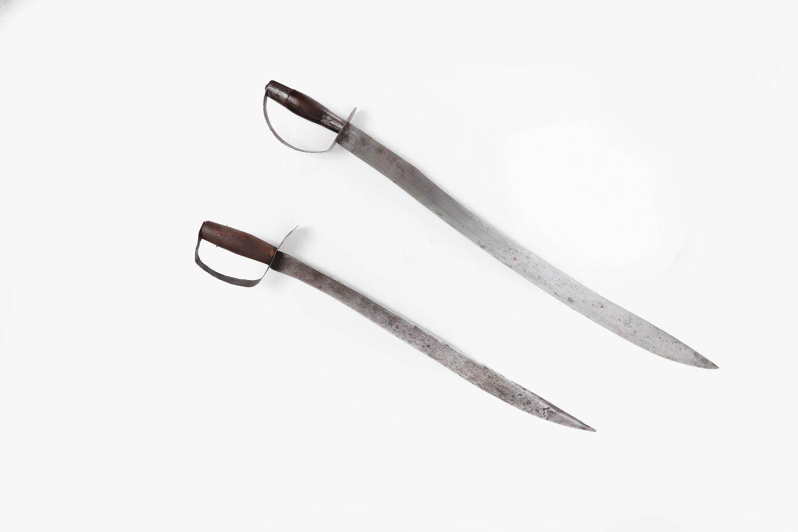 Pair of Spanish Colonial Luzon swords, Circa 1860-90: Set of two Spanish Colonial Luzon, Civil War Period circa 1860-1890 with characteristic D-Shaped guard. Larger example a massive gently recurved blade with single edge.