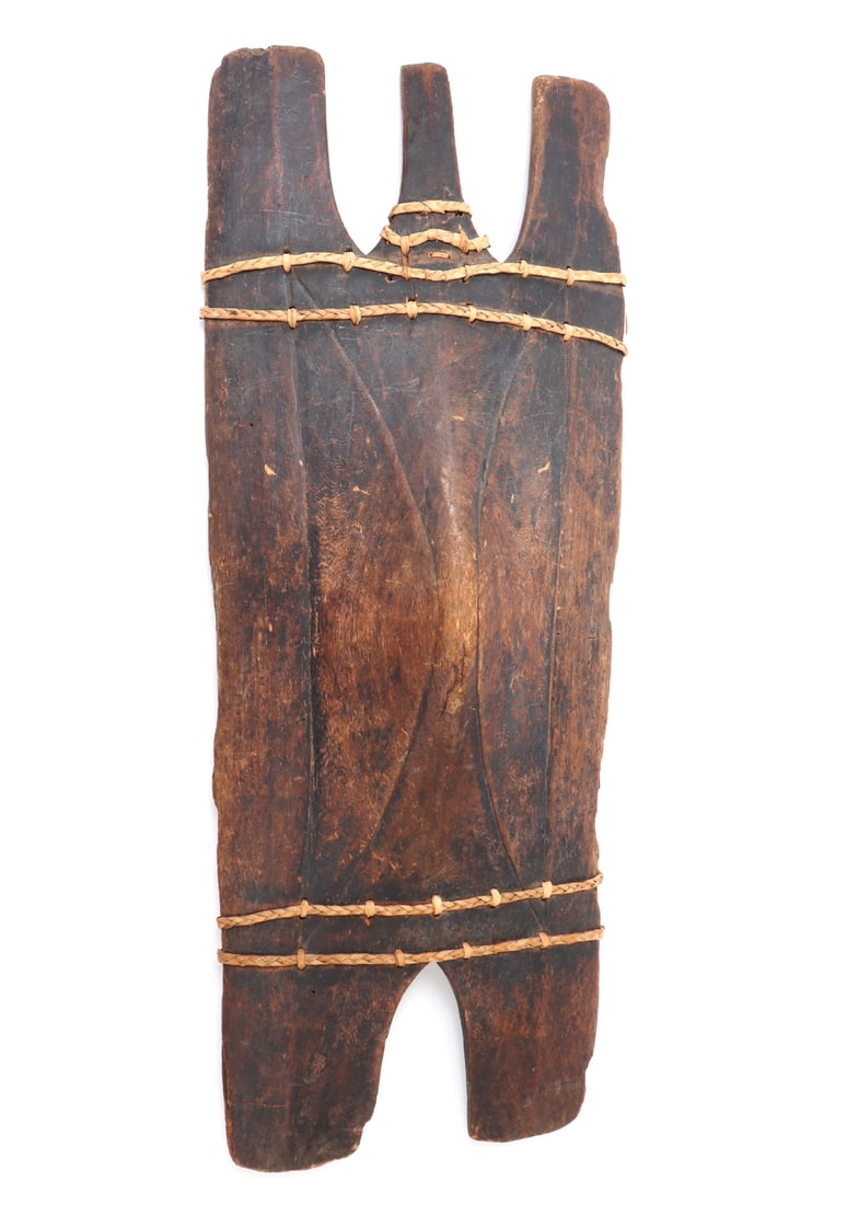 Ifugao Wood Shield, Luzon: Early Philippines Ifugao shield from the Luzon province carved in a light wood with rattan wrapped reinforcements. The face carved with three legs to one side and two to the other with the central