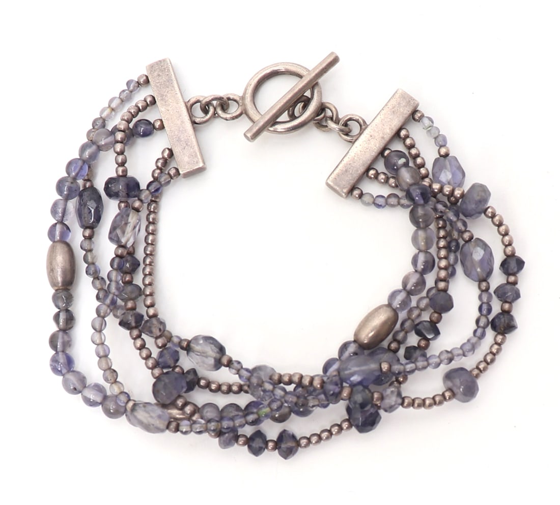 Lovely Amethyst & Silver Bracelet: Dozens of delicate amethyst beads banded with dozens of silver beads throughout. Bar loop clasp with infinity loops attached to the suspension bar with silver dot details. Size 7" L