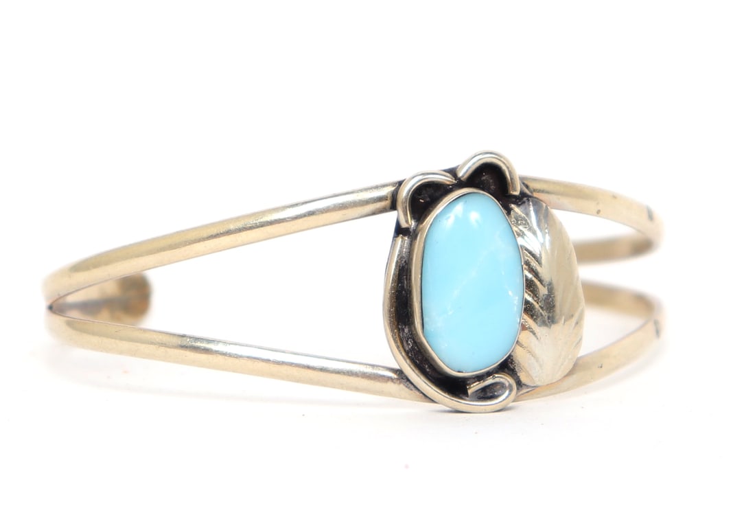 Gorgeous Sterling Silver & Turquoise Native American Bracelet: Stunning Navajo made turquoise and sterling silver bracelet. Oval turquoise polished stone to the face inset in a leaf bezel. Size 2 1/8" W end to end, 1 1/4" W opening