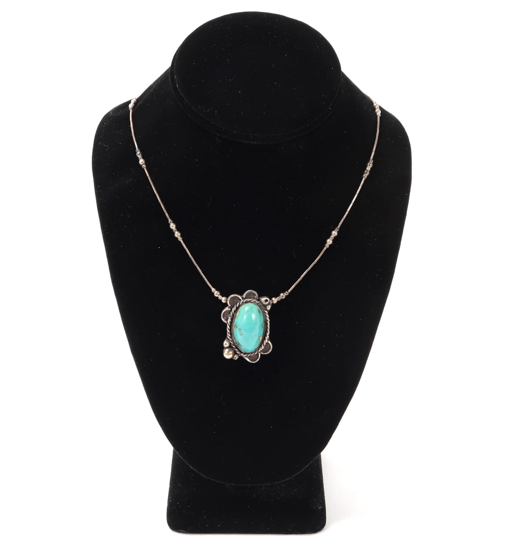 Lovely Turquoise & Sterling Silver Necklace: Beautiful hand crafted turquoise and sterling silver necklace. Turquoise bead is surrounded by a twisted rope frame with flower petals. Sterling silver chain with sterling spacer beads accenting in