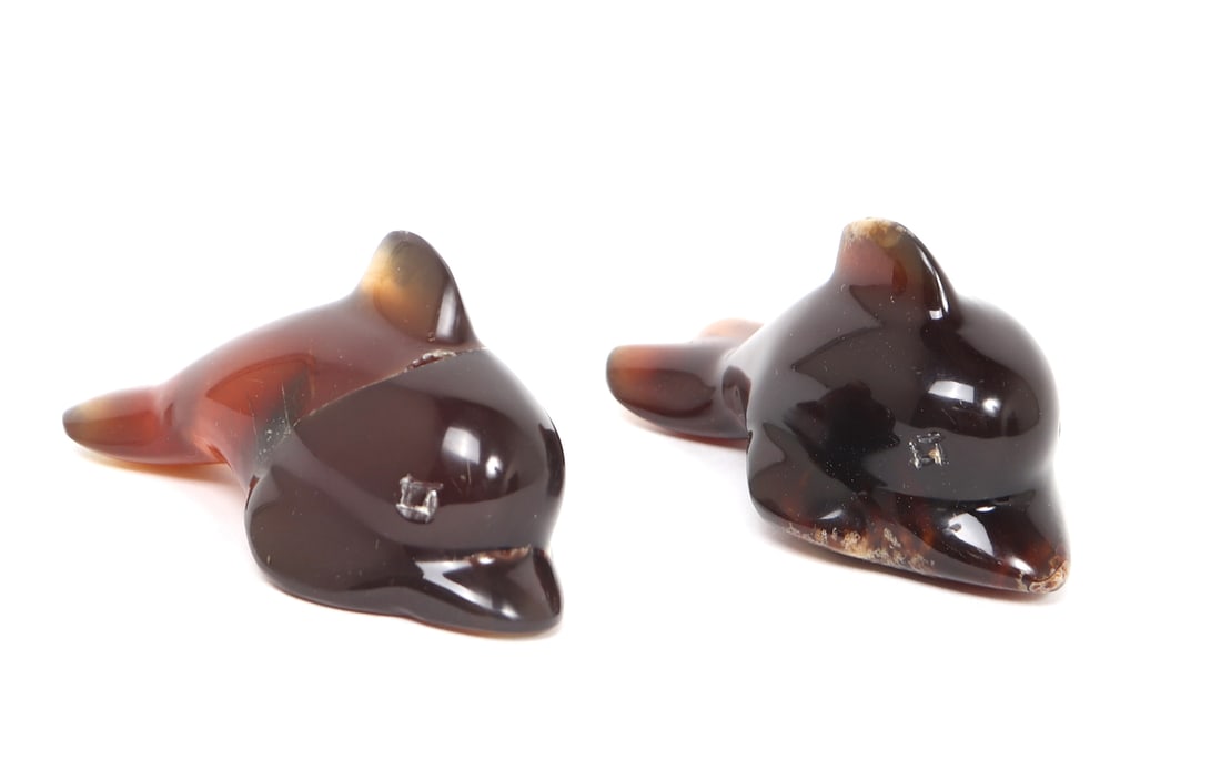Pair of Blue Amber Carved Dolphins: Gorgeous pair of hand carved and polished blue amber dolphin figurines. Blue amber when illuminated by black light with glow bright blue, giving them their true name of blue amber. Each dolphin has
