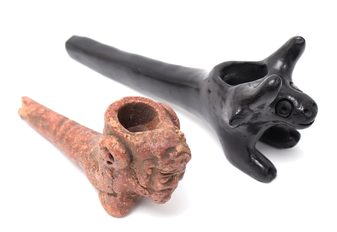 Two Handcrafted Animal Pipes: Two nicely crafted pipes, one a terracotta orange with a zoomorphic bird creature the other a jet black ox with protruding horns. Also note the black pipe is inscribed to the exterior. Size 5 1/4" L