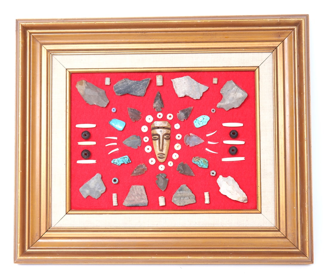 Framed Collection of Native American Artifacts: Lovely framed collection of various Native American artifacts. Center feature piece is a bone carved face pendant, surrounded by shell and glass beads, arrowheads, animal teeth and more. This would ma