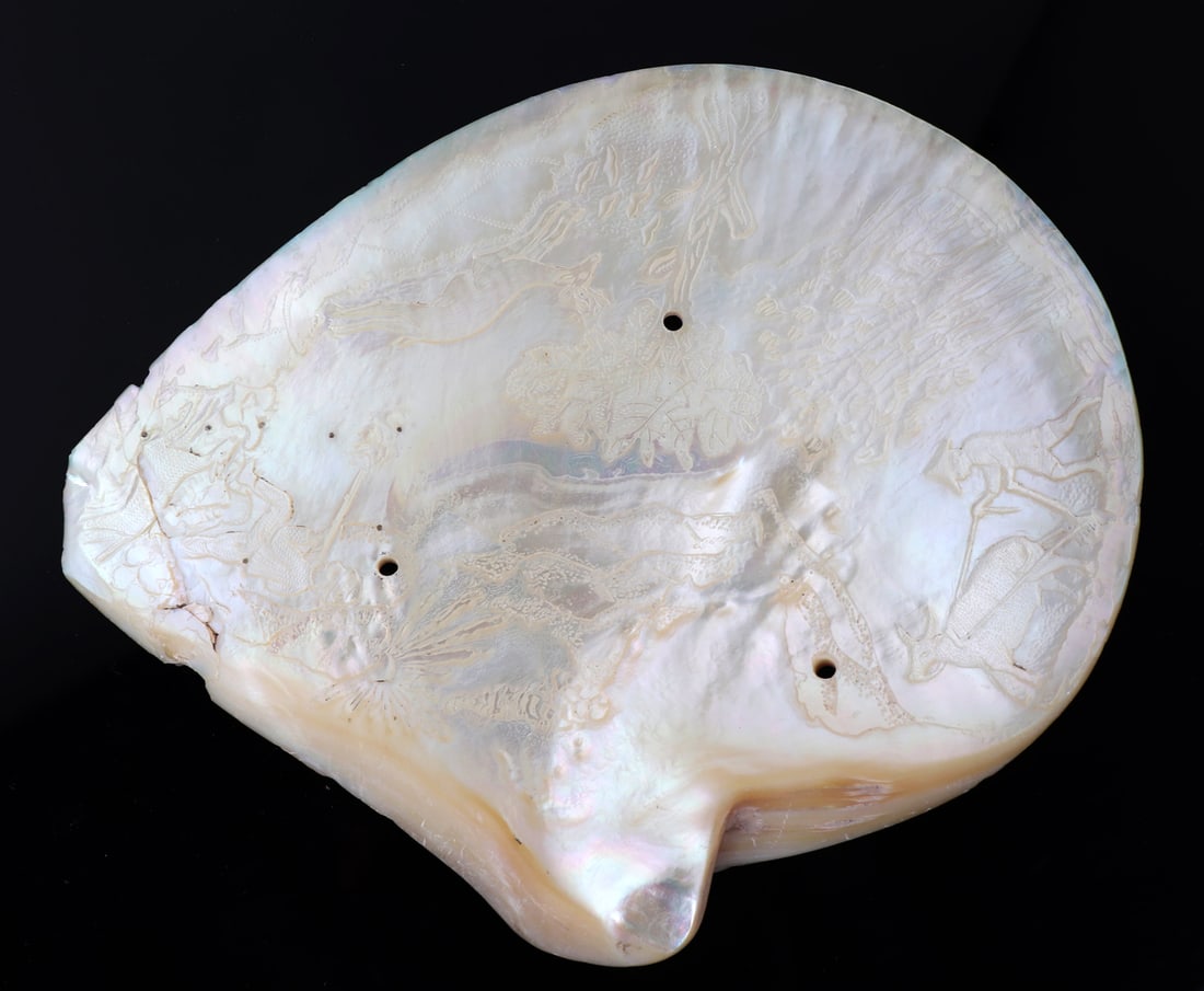 Intricately Carved Clam Shell: Beautiful craftsmanship and attention to detail went into the making of this beautifully carved sea shell. Depicting a man tilling his garden with an ox, a stag running around the forest among trees a