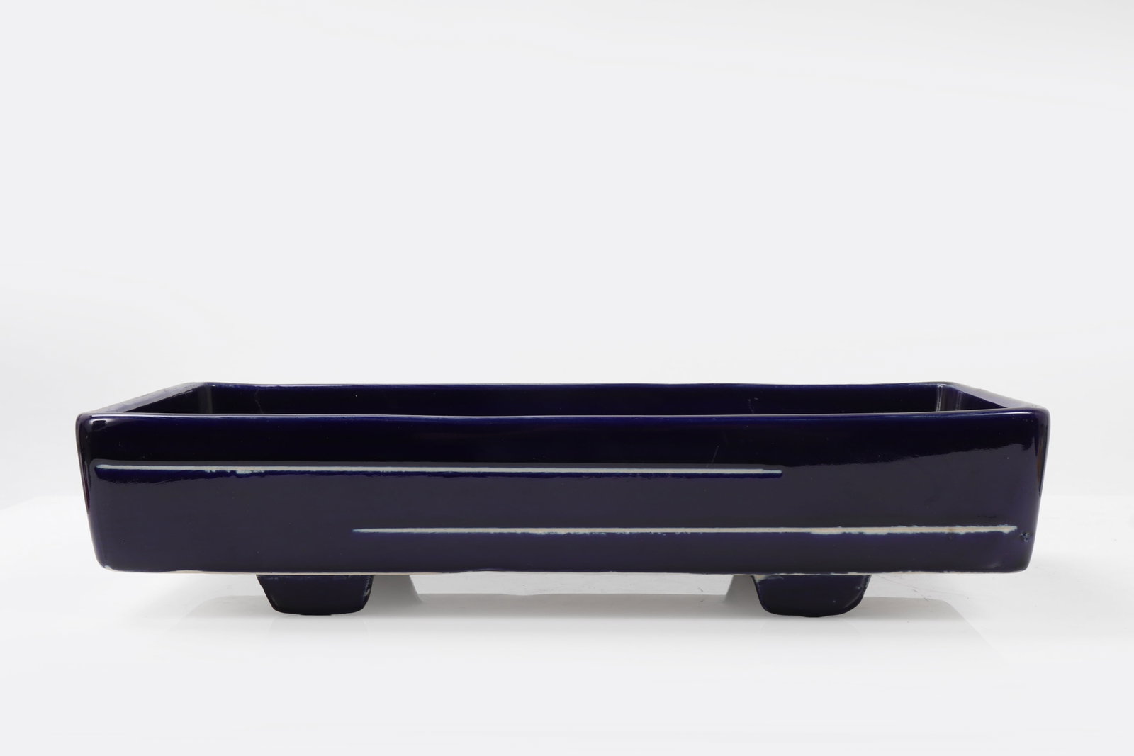 Ceramic Navy Blue Bonsai Pot: This elegant piece features a deep navy blue glaze, lending a serene and classic appearance, ideal for showcasing bonsai artistry. The pot is crafted with clean lines and sturdy feet, ensuring