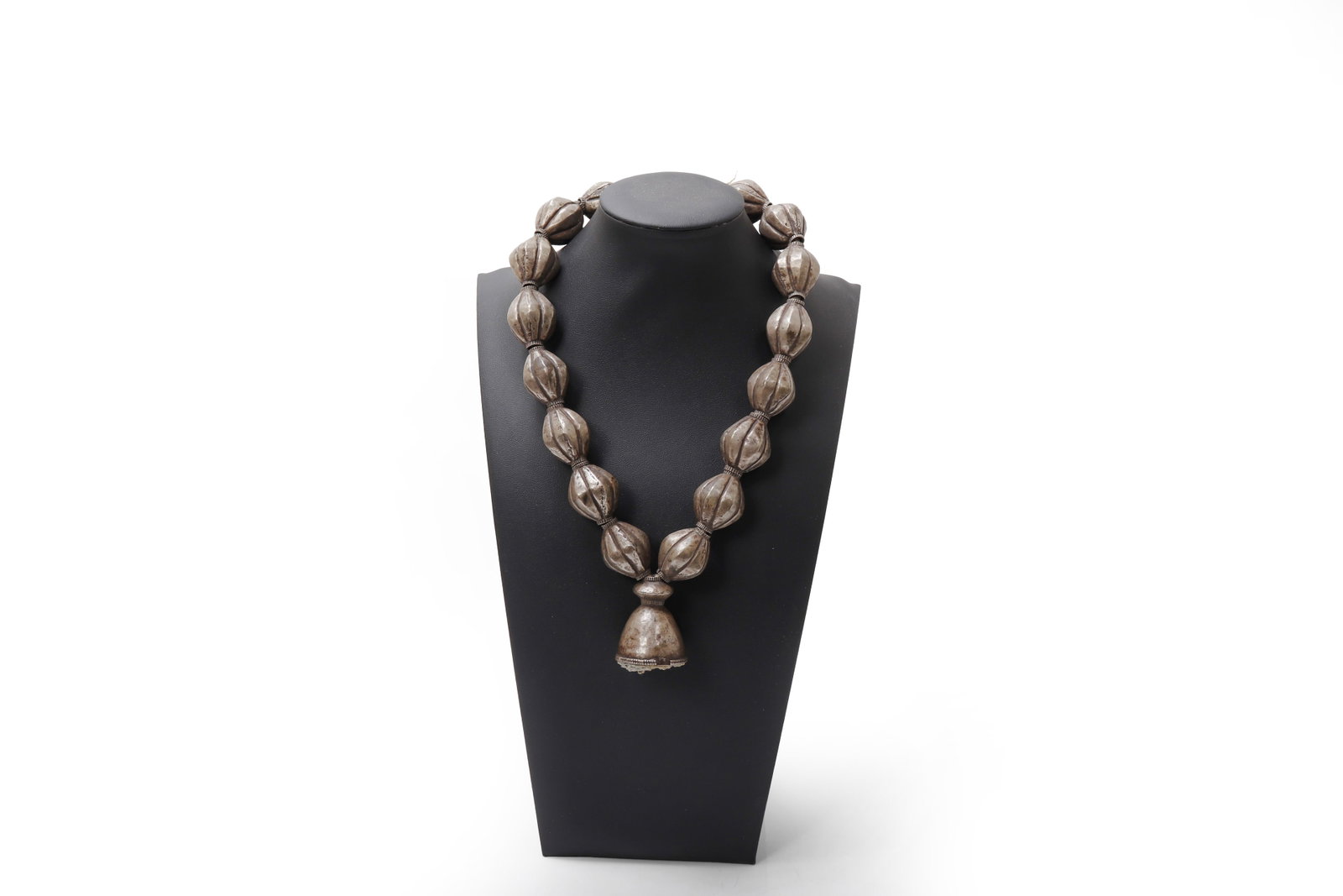 Nepali Silver Bell & Melon Bead Necklace: Composed of a sequence of large, hollow-cast silver beads of lobed "melon" form, each articulated with subtle ribbing and separated by narrow collar spacers, the strand terminating in a substantial