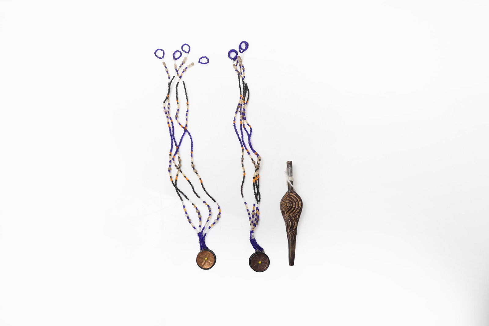 Glass Bead Necklace & Pendant, Southeast Asia 19th-20th C.: Southeast Asia, 19th to 20th century. Group of three ornaments, comprising two circular pendants suspended from multistrand glass bead hangers and one separate elongated pendant carved ornament of