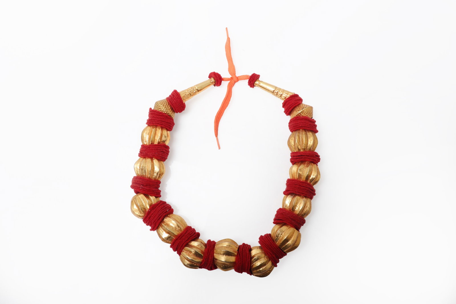 Nayar Wedding Necklace, mid-late 20th C.: Nepal Newar community, mid-late 20th century. Ceremonial wedding necklace composed of large ribbed gilt beads separated by vivid red wrapped fiber spacers, the strand finished with tapered terminal