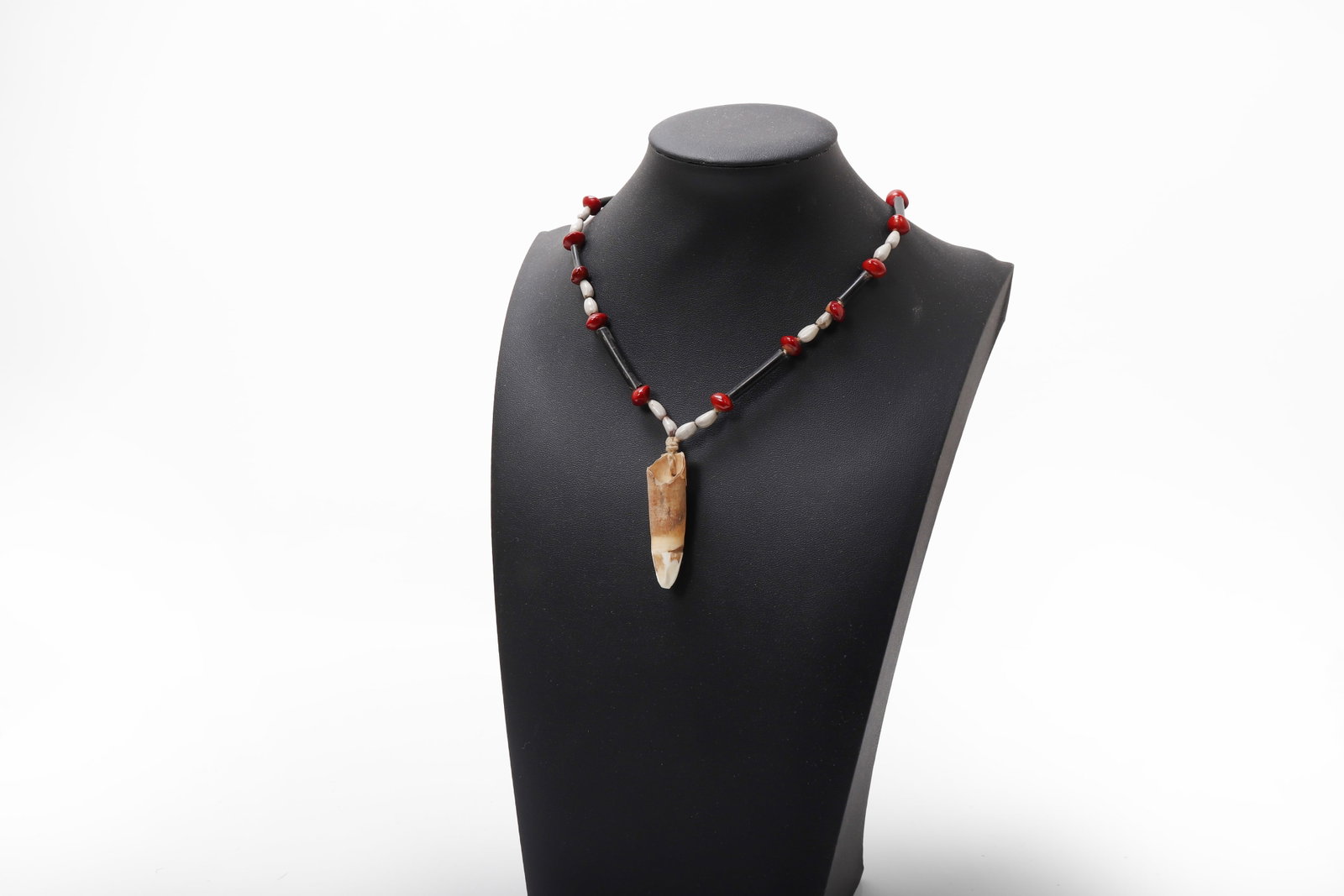Asmat Tooth-Form Pendant Necklace: Southwest New Guinea (Papua, Indonesia), Asmat Region, mid 20th century. Necklace composed of alternating red, dark, and pale beads strung in a symmetrical arrangement, interspersed with elongated