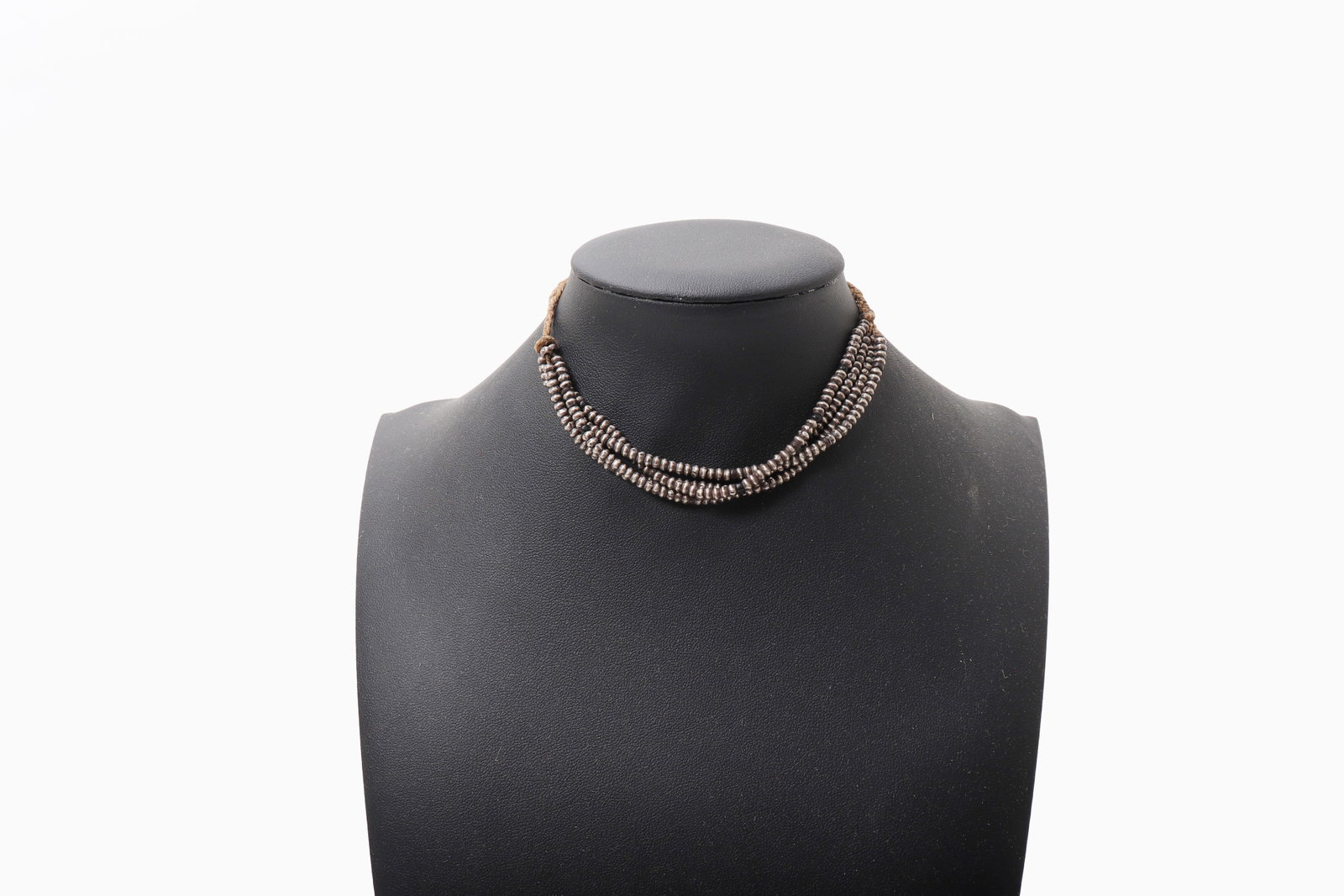 Indian Silver Baby Necklace: India, 19th to early 20th century. Composed of multiple strands of closely spaced, disc-form silver beads, strung on twisted fiber cord and gathered at the ends with simple knots. The compact,