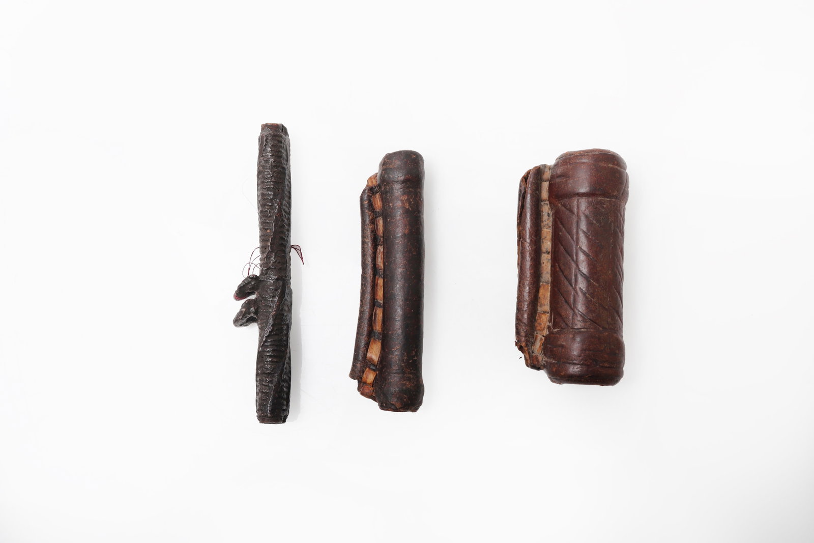 Ethiopian Magic Healing Scroll Pendants: Ethiopia, 19th - 20th century A group of three Ethiopian protective amulets, or kitabe, each formed as a small leather pendant enclosing a tightly rolled parchment scroll intended for personal