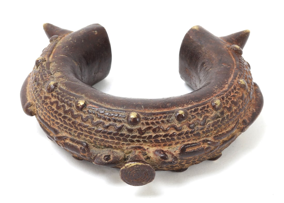 African Bracelet, Burkina Faso: This remarkable bracelet is an exquisite example of traditional African metalwork from Burkina Faso, featuring intricate linear geometric surface designs with raised patterns. Crafted from bronze, it