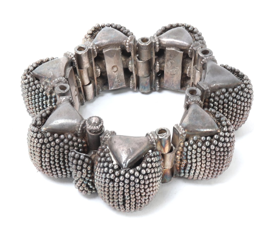 Indian Bangle of 7 Large Beaded Humps: Large oversized Indian "moti ke gajre guchchha" bangle in silver circa late 1800s. Decorated with seven large humps covered in small bead spheres over the surface. Hinged to the interior with a pin