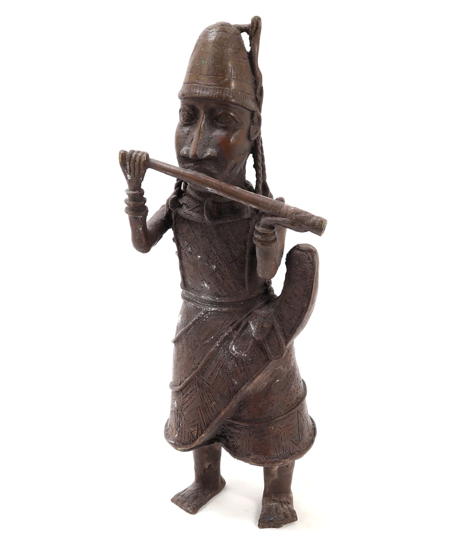 African Bronze Musician Statue: Exceptional depiction of an African Horn / Flute player cast in the lost wax bronze technique. Adorned n ceremonial attire and featuring a tall, domed hat. The figure is expertly crafted showcasing