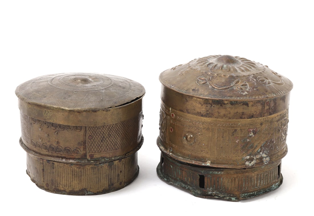 Ashanti Gold Container(s): A fine group lot of two late 19th century Ashanti (Asante) gold dust containers, crafted in brass and richly adorned with traditional embossed checkering and geometric patterns throughout. Each