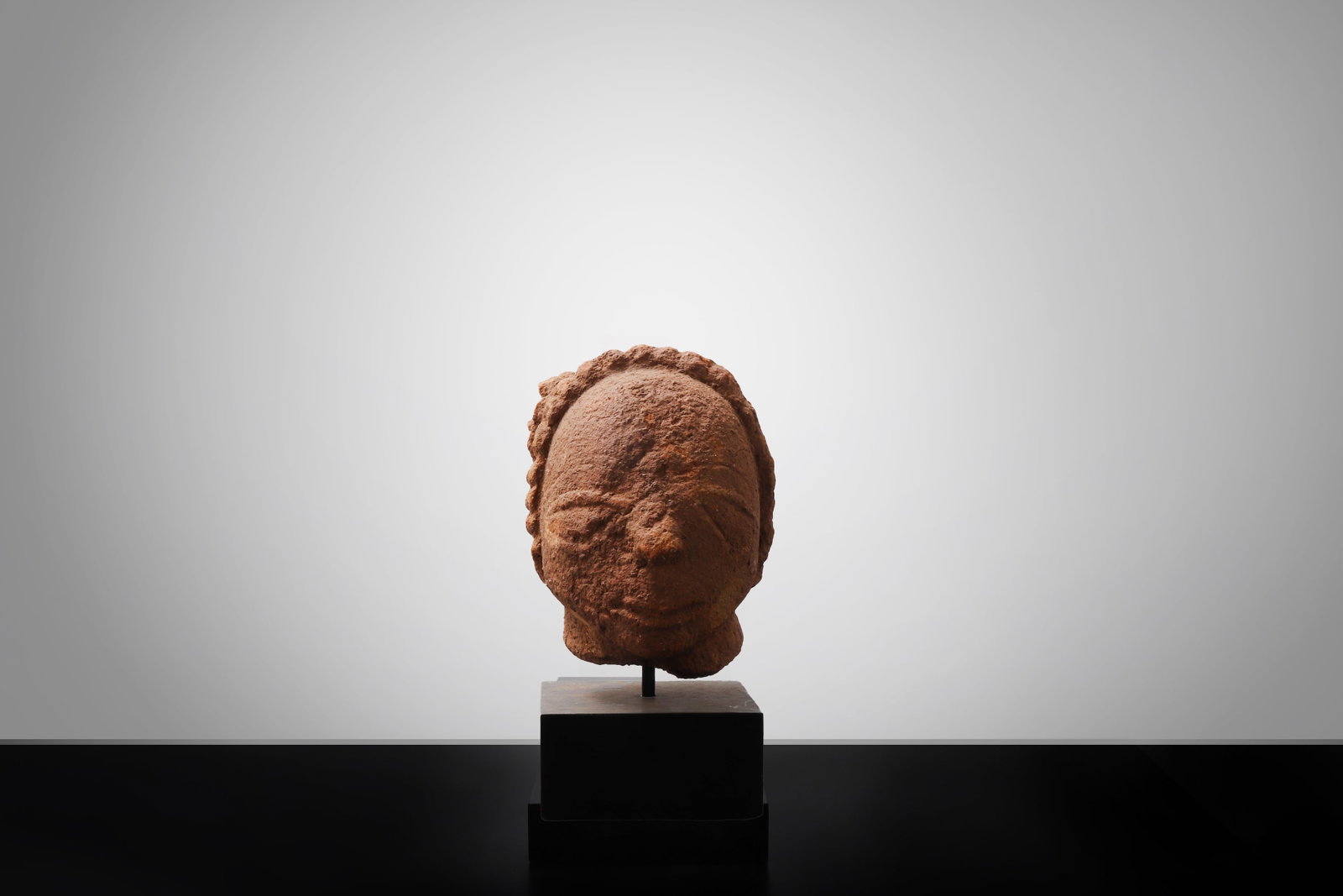 Nok Terracotta Female Head, 500CE - 200CE: West Africa, possibly Nigeria, Nok Circa 500 BCE ? 200 CE A finely modeled terracotta female head, the serene face rendered with softly defined almond-shaped eyes, a straight nose, and composed