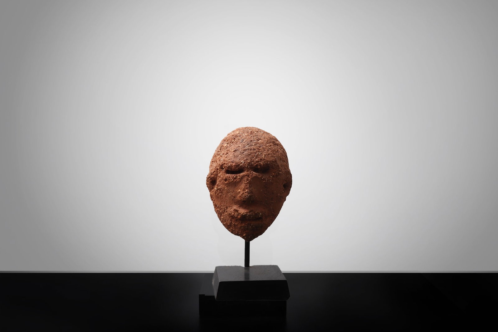 Nok Terracotta Head Fragment, Probably 500 BCE?200 CE: West Africa, likely Nigeria, Nok culture, probably 500 BCE - 200 CE. A terracotta head fragment modeled in rounded form, with recessed slit-form eyes, pierced nostrils, and a small projecting mouth.
