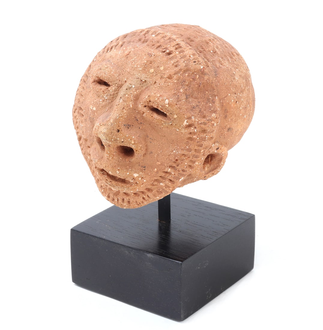 Terracotta Male Nok Head on Custom Stand: Nigeria, circa 500 BC to 200 AD. Wonderful hand crafted terracotta male Nok head on a custom stand. Facial features include slit eyes and flared nostrils, beard like detailing around the chin. Size 4 