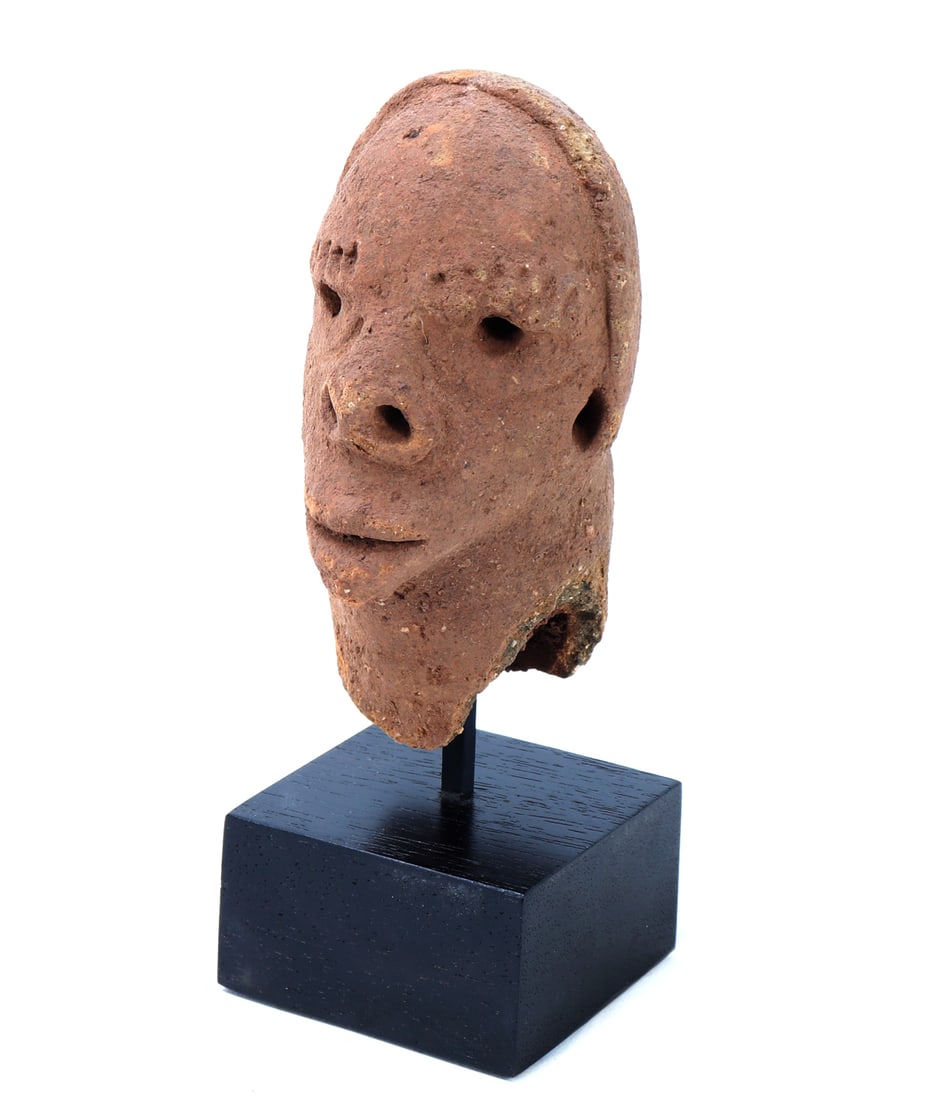 Sokoto Terracotta Head: Northern Nigeria, Sokoto culture, likely circa 500 BCE - 200 CE. An authentic terracotta head modeled with a rounded cranium, projecting nose, pierced eyes and nostrils, and a small smiling mouth abov