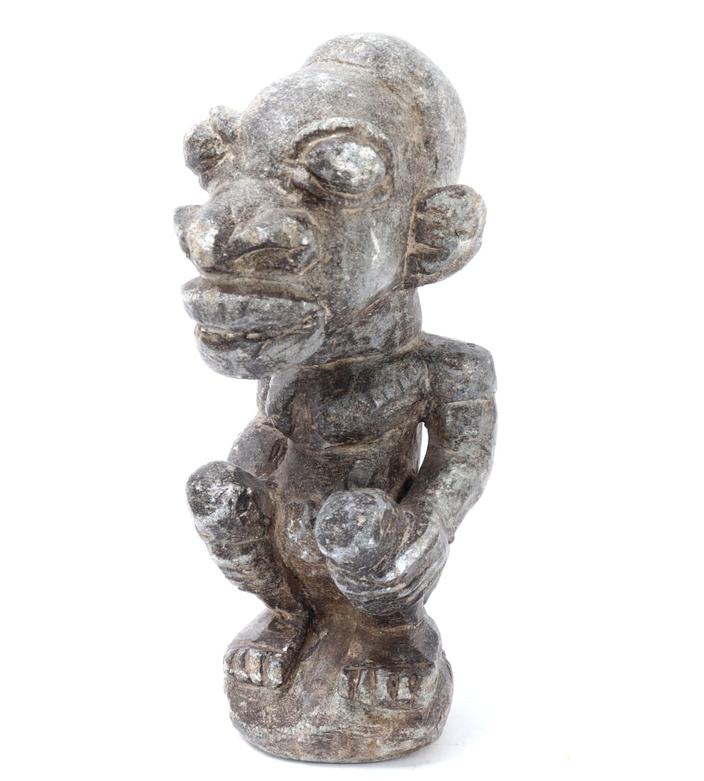 Stone Carved Figure, Sierra Leone: Stone carved figure from Sierra Leone showcases intricate craftsmanship and cultural significance of Kissi Nomoli figures. The piece reflects traditional carving techniques, emphasizing bold features