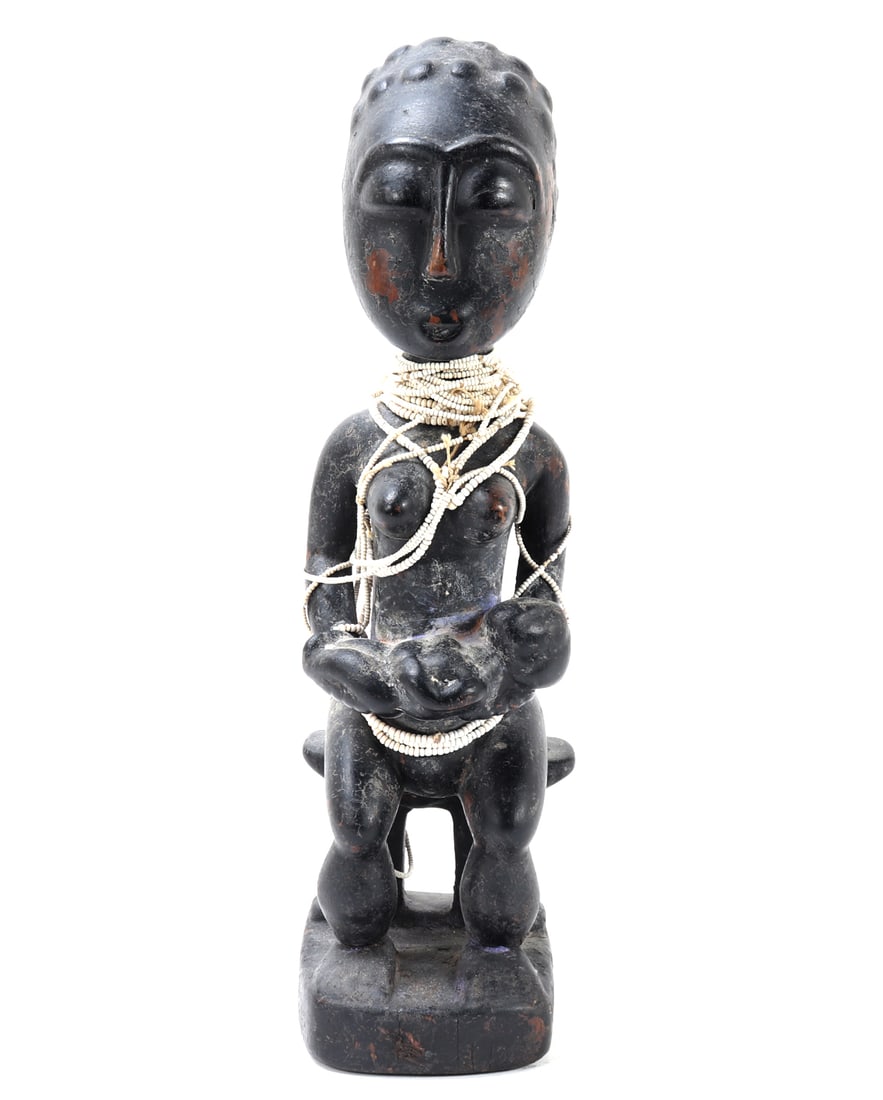 Abron / Akan Maternity Figure, Ghana: West Africa, Ghana, Abron / Akan peoples, 20th century A finely carved wooden maternity figure depicting a seated mother holding an infant across her lap. The female figure is shown nude, seated upon