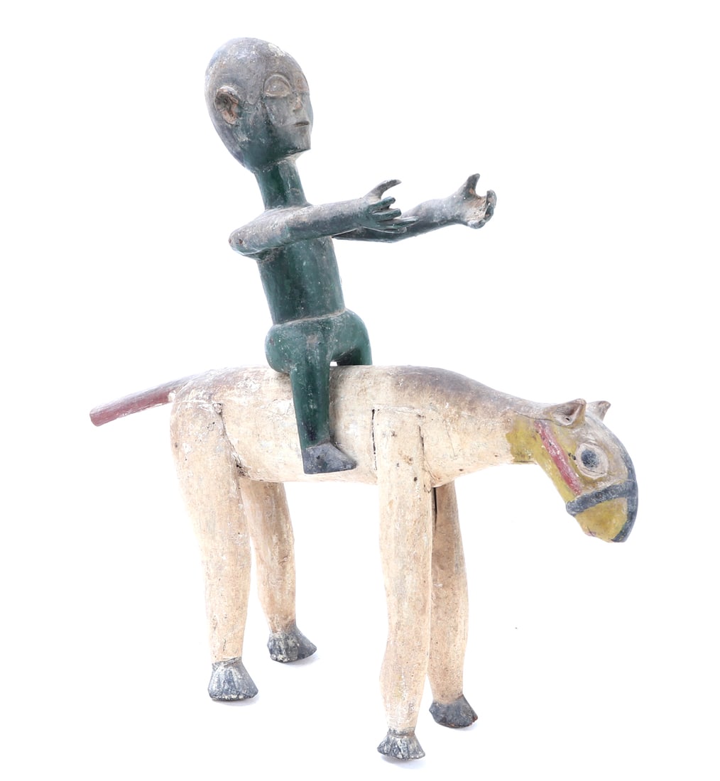 African Carved Wood Equestrian Figure & Horse: Fine African folk art wood carving of a slightly rearing horse with a green colored male figure holding outstretched arms of offering with a satchel over his shoulder. The horse in a cream white