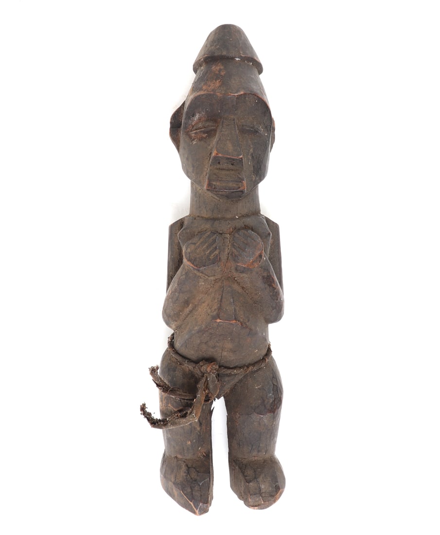 Unique African Wood Fetish Figure: African wood carved statue of a man with his hands held to his chest with a rope around his waste. Elongated head with a pointed hat on top. Size 11 1/4" L, weight 396 g Collected prior to 2008, ex-La