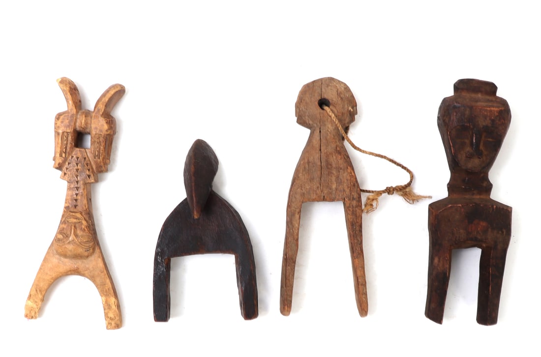 Group of Four African Wood Pulleys & Slingshot: Group of three African wood pulleys and a Baule slingshot. Left most a Baule slingshot with carved Janus faced heads to the base and a single carved face to the center of the grip. Next three African 