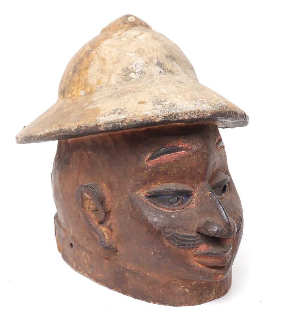 Gelede Helmet Mask, Yoruba Peoples: West Africa, Costal West Africa, Nigeria, Yoruba people, more probably Egbado peoples Gelede helmet mask. Male head mask with a colonial hat and dark tones skin with a mustache. Used in the annual Gel