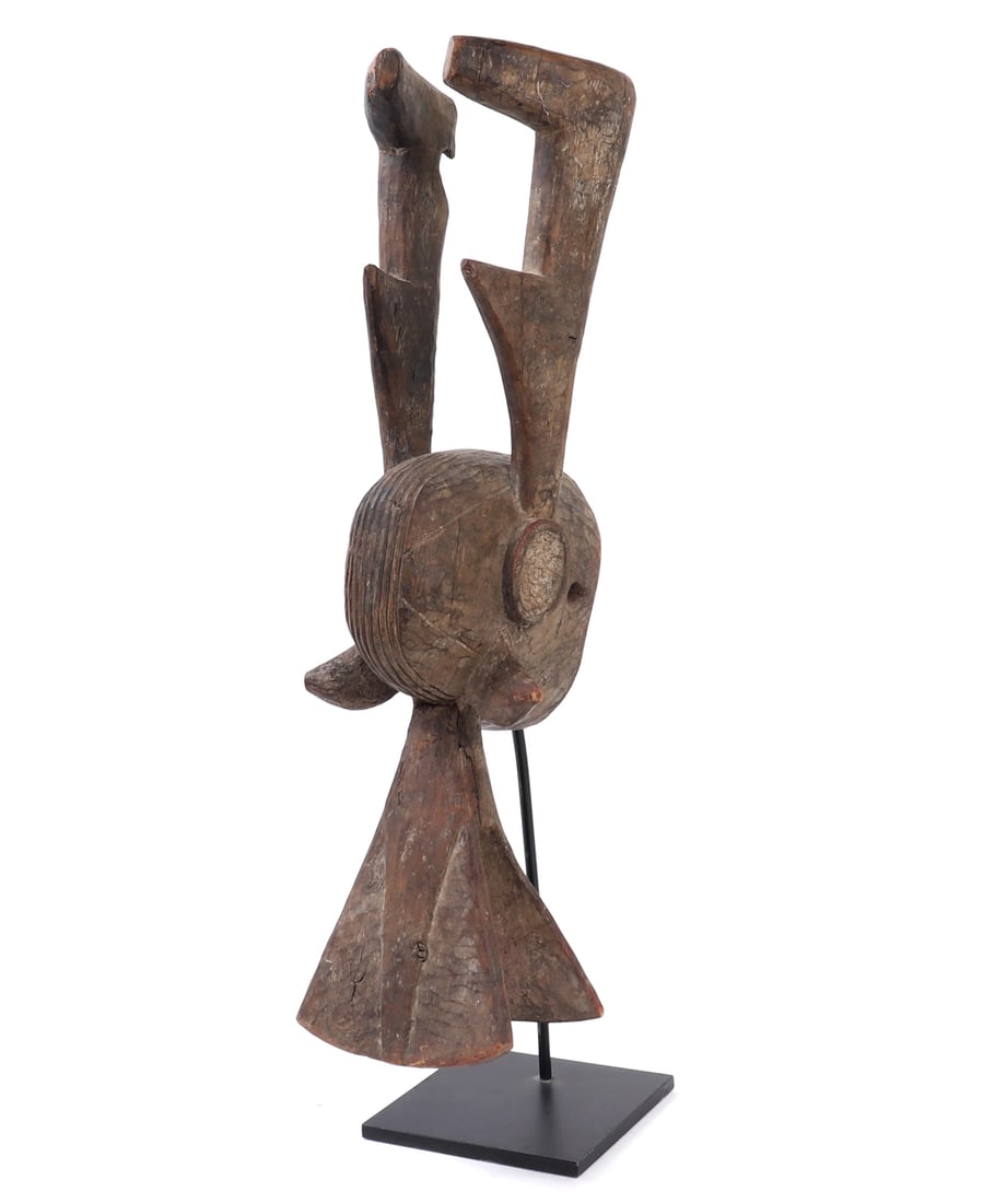 Bambara Ci Wara Antelope Crest: Mali, Bamana/Bambara peoples. A carved wood Ci Wara headdress or crest, modeled in highly abstracted antelope form with elongated vertical horns, projecting ears, and a rounded head above a flaring
