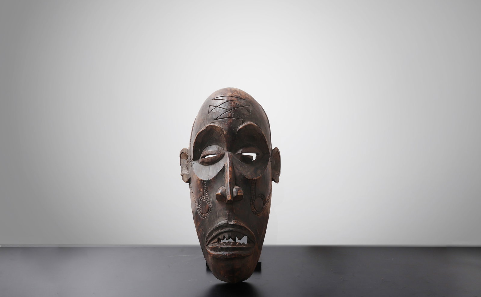 Chokwe Carved Wood Mask, Central Africa: Central Africa, Chokwe peoples, Angola / Democratic Republic of the Congo / Zambia region, early 20th century. An antique Chokwe carved wood mask of powerful elongated form, the face rendered with
