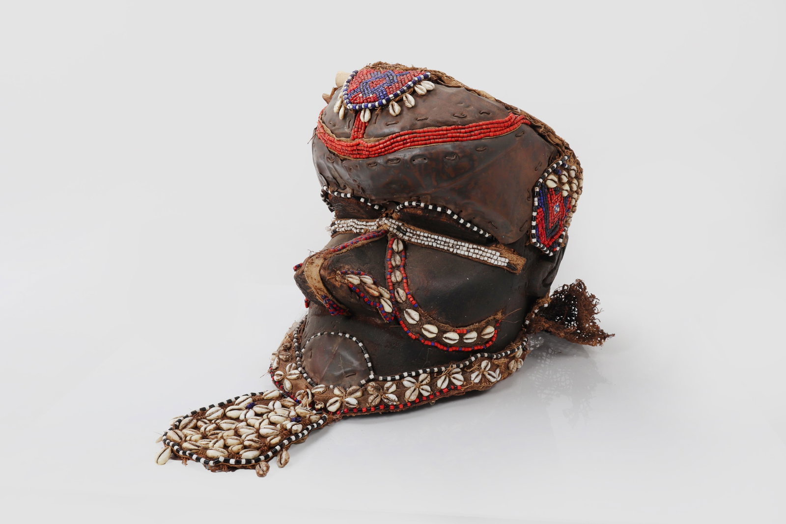 Kuba Bwoom Helmet Mask: Democratic Republic of the Congo, Kuba peoples, 20th century A striking carved wooden Bwoom helmet mask of powerful sculptural form, the rounded head and projecting facial planes enriched throughout