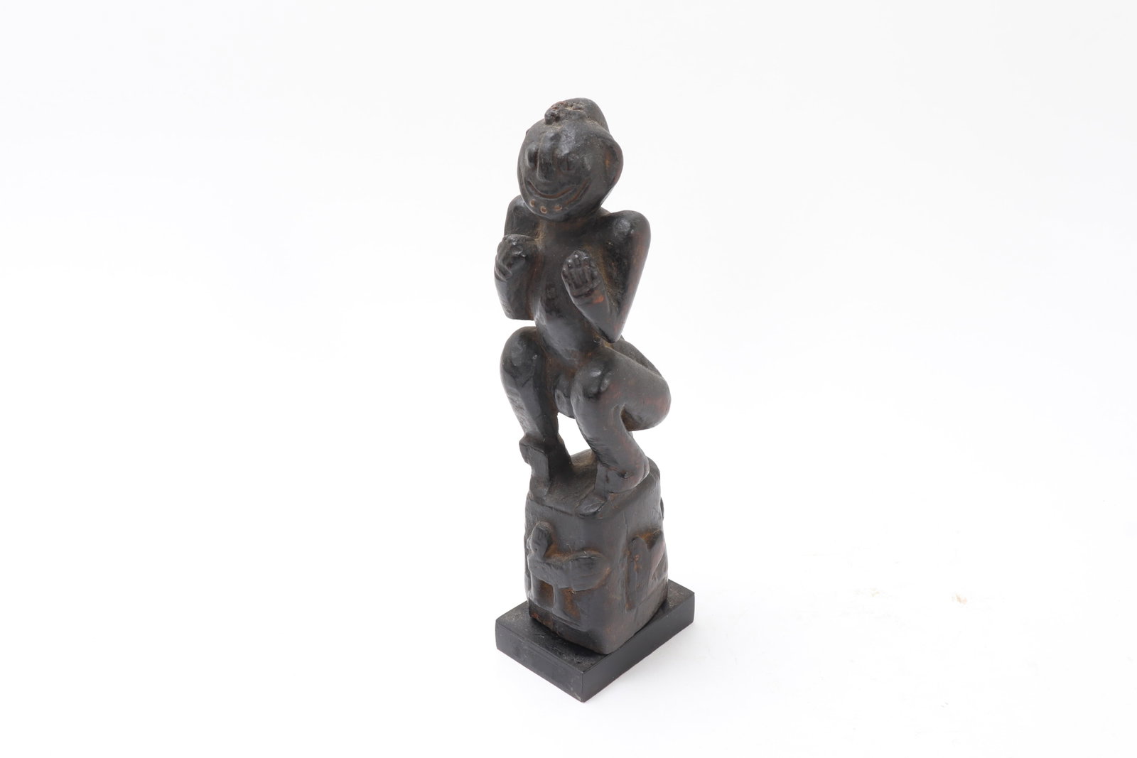 Burmese Carved Wooden Oxcart Ornament: Burma (Myanmar), probably 19th century or earlier Carved wooden figure in a crouching pose, with bent legs, raised forearms, and a highly stylized expressive face, standing on an integral rectangular