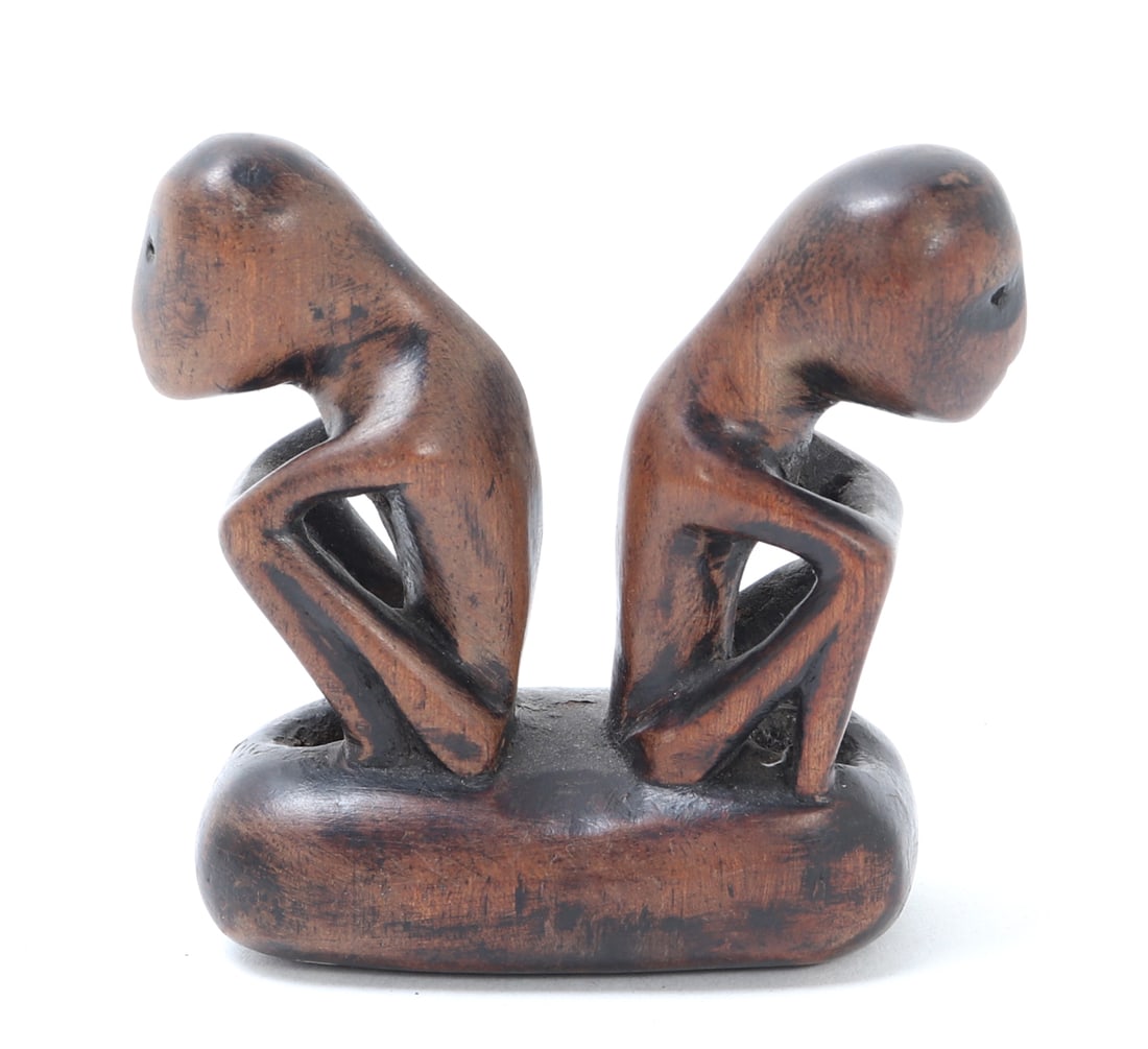 Miniature Carved Double Figure, Philippines: Philippines, 20th century Small carved wood sculpture depicting two stylized seated figures set back-to-back on a shared oval base. 2.5" W