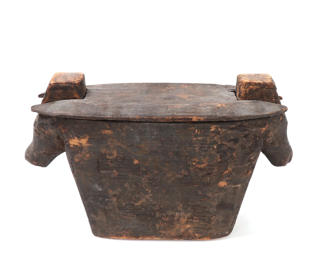 Ifugao Punamhan Ritual Box: Philippines, Ifugao, carved wood punamhan ritual rice box, of elongated rectangular form with rounded ends and a removable fitted lid. The vessel is carved with projecting stylized animal heads at