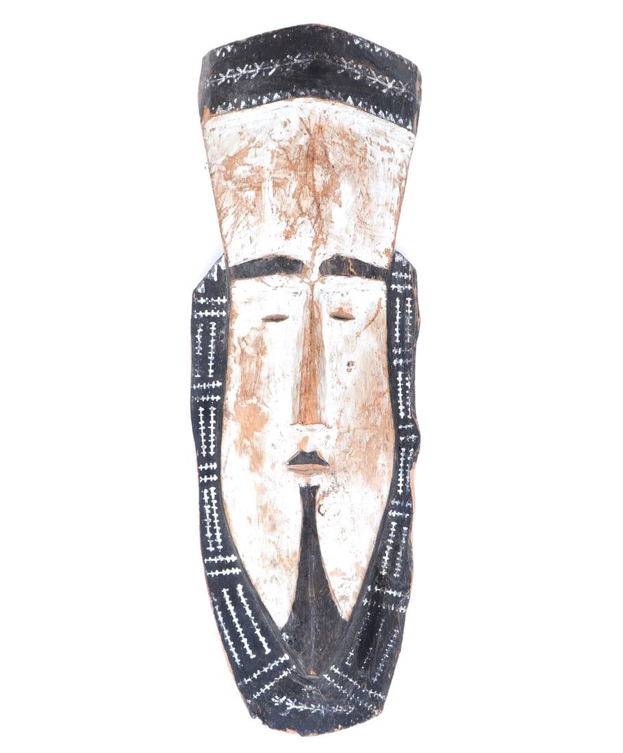 Oceania Wooden Tapuanu Dance Mask: Oceania, Micronesia. Known in their language as "tapuanu", it is hand-carved from breadfruit wood and painted using lime white and soot black. In the characteristic style of Nomoi masks, everything