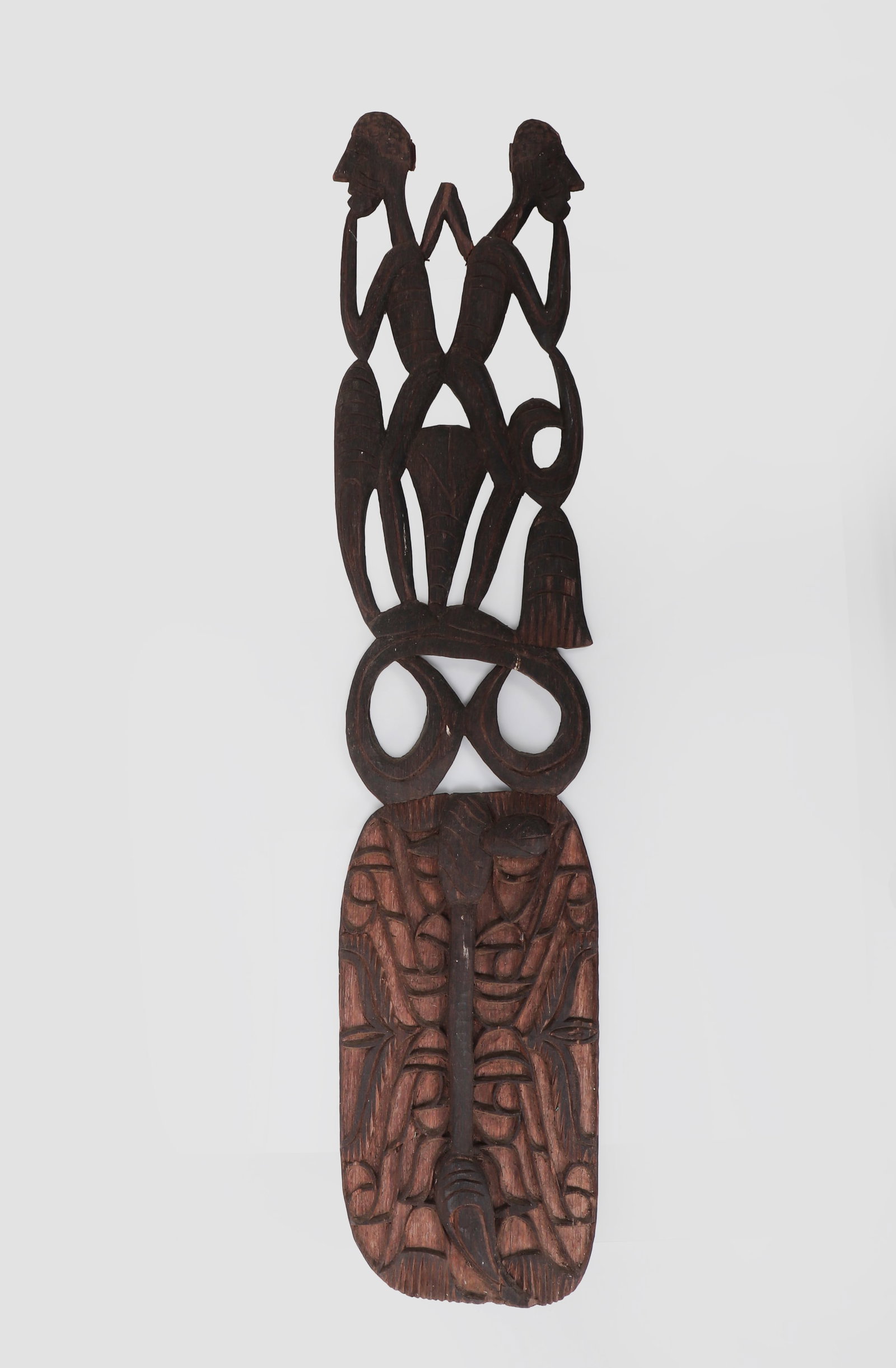 Asmat Carved House Protector: Asmat carved wooden house protector, Papua, Indonesia, 20th century, with openwork paired ancestral figures above a rectangular relief-carved panel. Dark patinated surface with age cracks, chips,