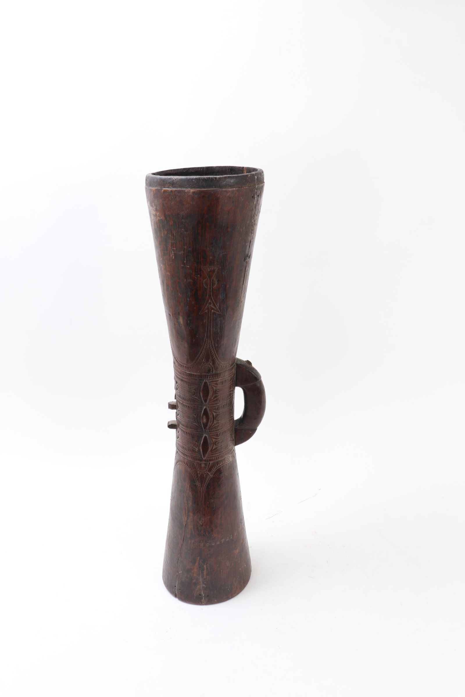 Papua New Guinea Carved Hardwood Slit Drum: Papua New Guinea, mid-20th century. Carved wood kundu drum of classic hourglass form, hollowed from a single section and fitted with a loop handle at the side. The waist is enriched with bands of