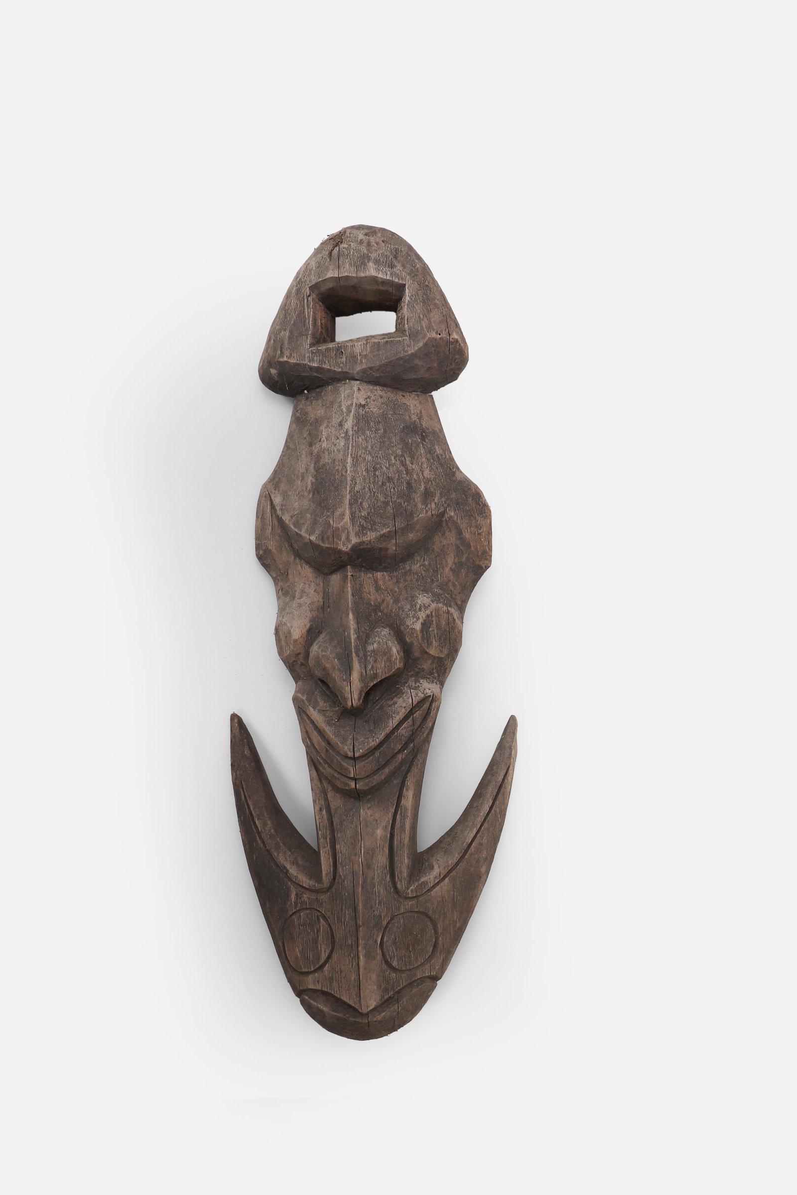 Papua New Guinea Carved Food Hook: Papua New Guinea, Sepik River region, 20th century. Carved wood food or basket hook with an elongated openwork body, stylized ancestral face, and large crescent-form hook at the lower end. The upper